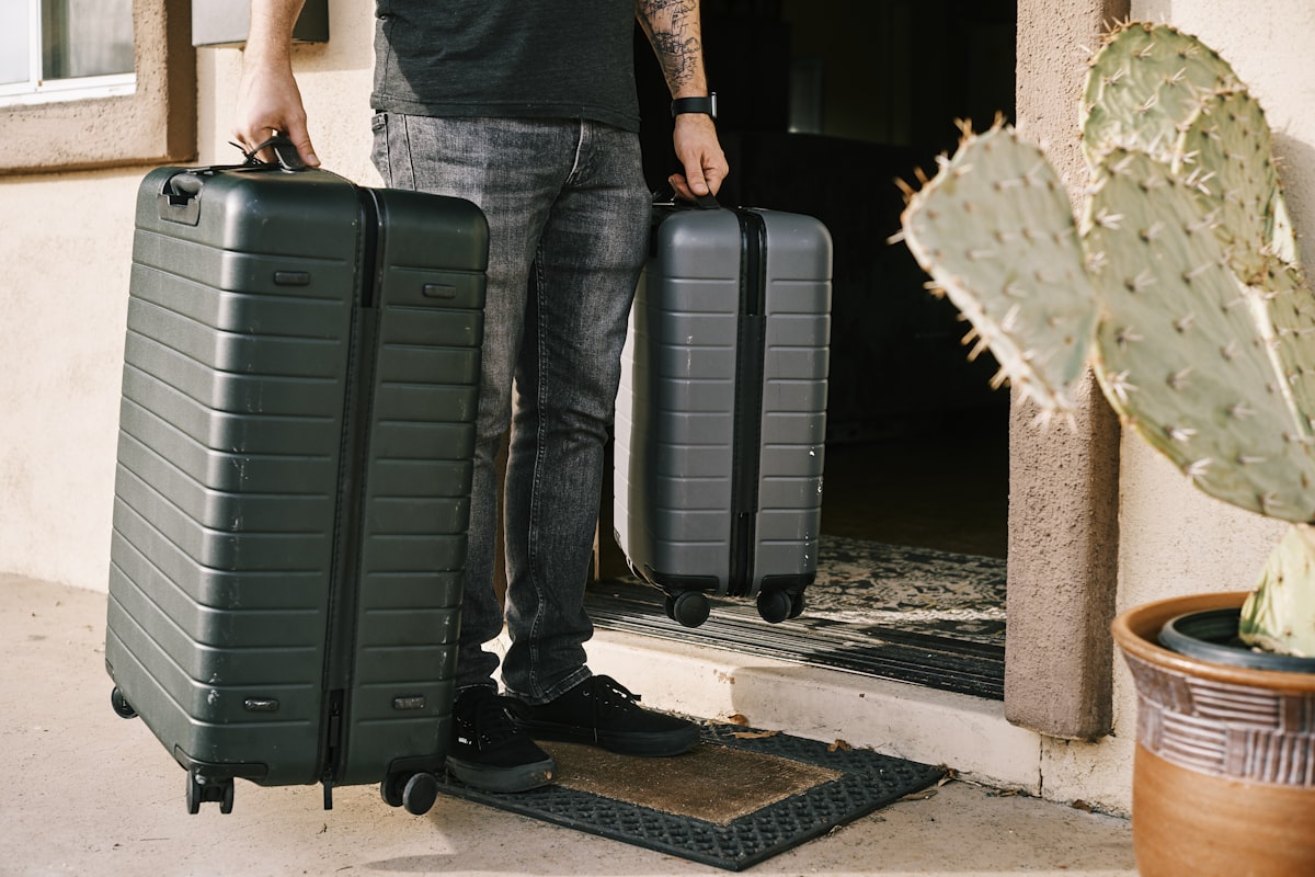 Voyageur debout à côté d'une valise rigide noire